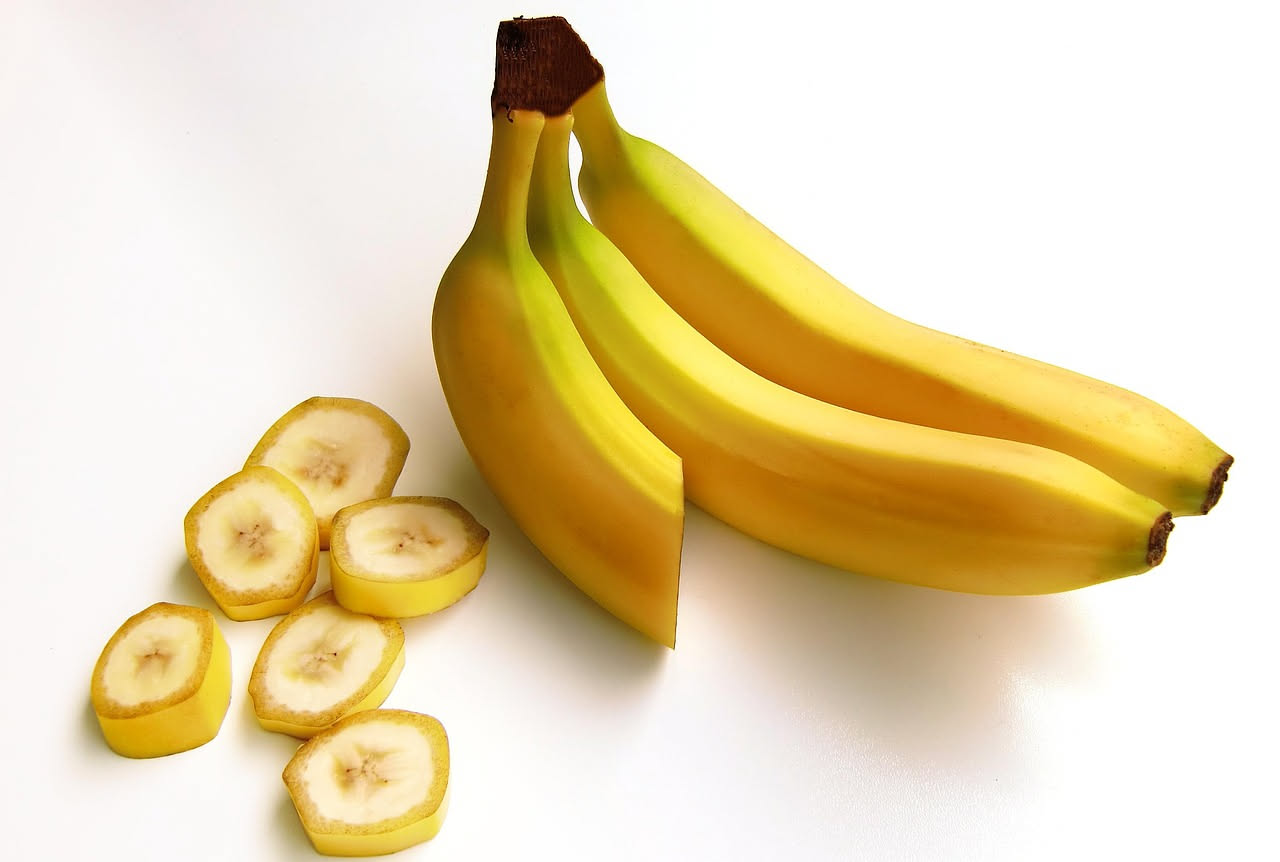 Tre banane su un tavolo, simbolo della dieta quotidiana e dei benefici nutrizionali secondo la scienza.