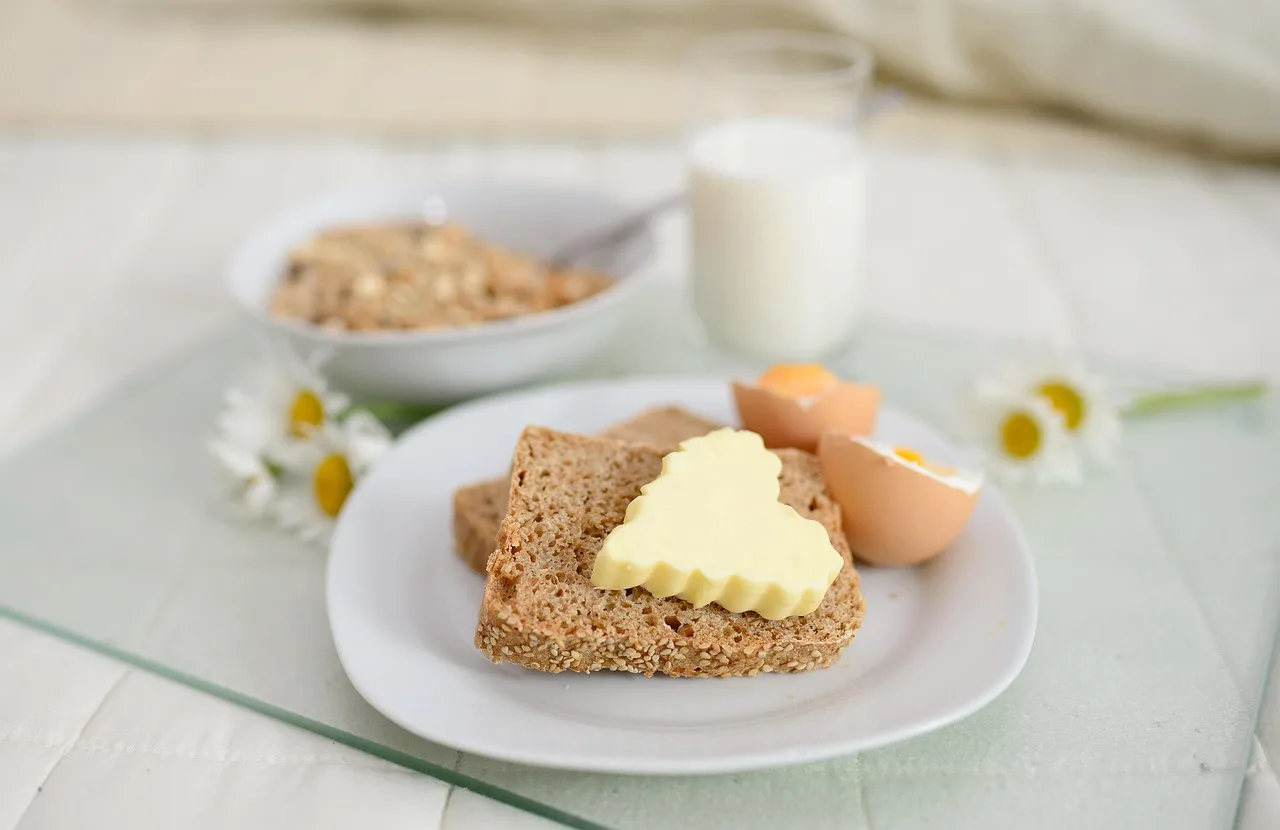 Fette biscottate integrali su un tavolo, accompagnate da marmellata e frutta fresca per una colazione sana.